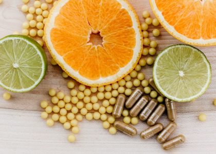 oranges, peas, and limes on a wooden table
